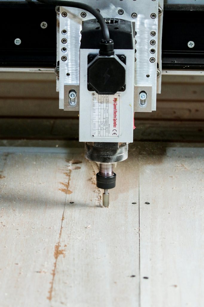 Precision CNC milling machine in action cutting wood for carpentry and industrial use.